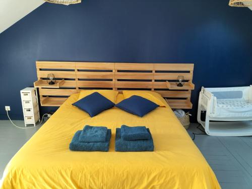 - un lit jaune avec 2 oreillers bleus dans l'établissement Charmante maison de ville, au Mans