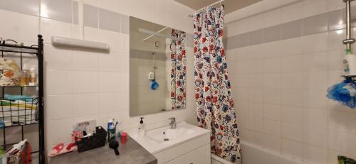 W łazience znajduje się umywalka i lustro. w obiekcie Appartement confort Clichy JO 2024 w mieście Clichy