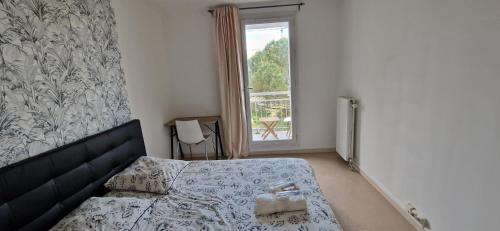 sypialnia z łóżkiem i oknem w obiekcie Appartement confort Clichy JO 2024 w mieście Clichy