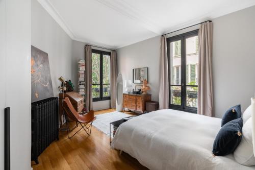 une chambre avec un lit et deux fenêtres dans l'établissement Luxe à Boulogne : Appart. Haut Standing, à Boulogne-Billancourt