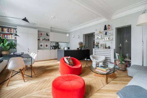 un salon avec une chaise rouge et une table dans l'établissement Luxe à Boulogne : Appart. Haut Standing, à Boulogne-Billancourt