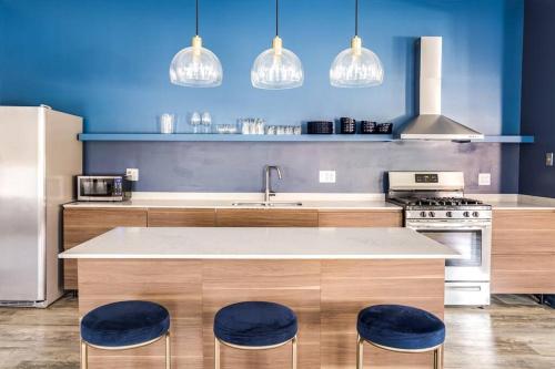 a kitchen with a counter with two blue stools at Beautifully Remodeled Second Floor Flat in River North with Private Rooftop - 2S in Chicago