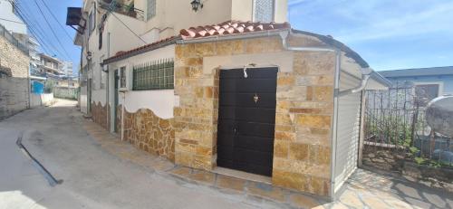 a brick building with a black door on a street at Sea & Relax Villa in Sarandë