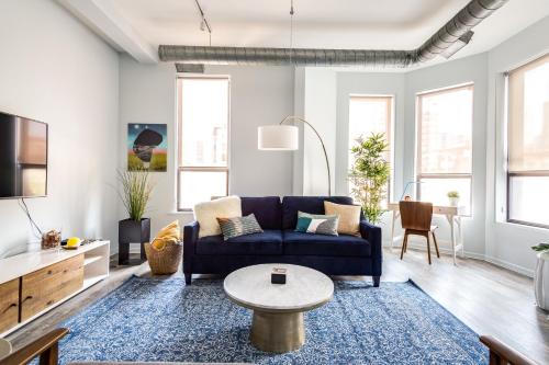 a living room with a blue couch and a table at Beautifully Remodeled Second Floor Flat in River North with Private Rooftop - 2S in Chicago