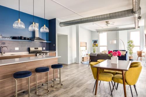 a kitchen and living room with yellow chairs and a table at Beautifully Remodeled Second Floor Flat in River North with Private Rooftop - 2S in Chicago
