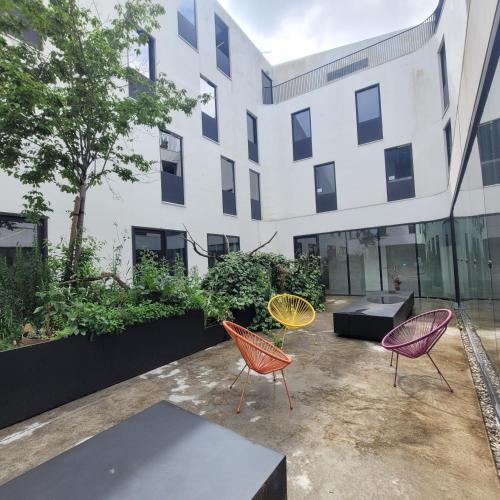 un groupe de chaises devant un bâtiment dans l'établissement Auberge de Jeunesse HI Cahors, à Cahors
