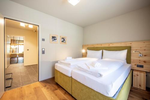 a bedroom with a large bed with white sheets at SWISSPEAK Resorts Meiringen in Meiringen