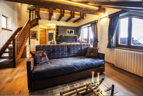 a living room with a couch and a staircase at Hotel Pilier D'Angle & Wellness in Courmayeur