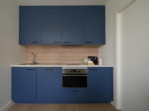 a kitchen with blue cabinets and a sink at Numa Madrid Sol in Madrid