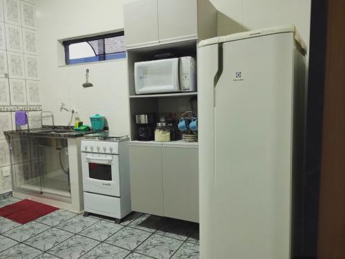 a kitchen with white cabinets and a refrigerator at Apartamento aconchegante em Cacoal4 in Cacoal