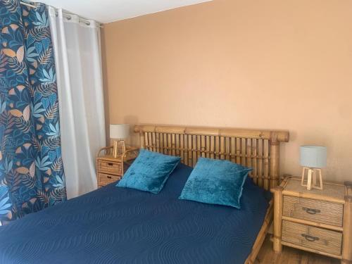 - une chambre avec un lit bleu et 2 oreillers bleus dans l'établissement Appartement T3 à 2 pas de la plage, à Saint-Cyprien