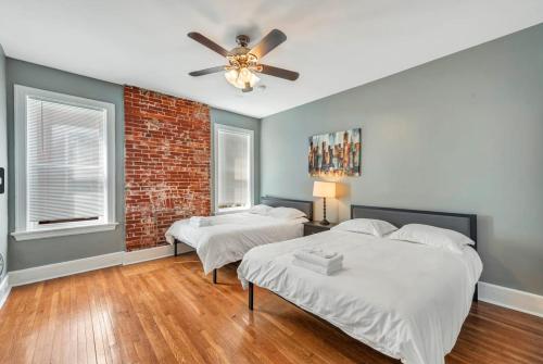 a bedroom with two beds and a ceiling fan at Historic First Floor Unit in McKinley Heights STL 1W in Soulard