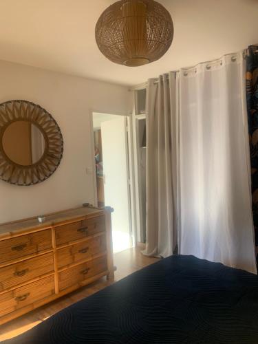 - une chambre avec un miroir et une commode dans l'établissement Appartement T3 à 2 pas de la plage, à Saint-Cyprien