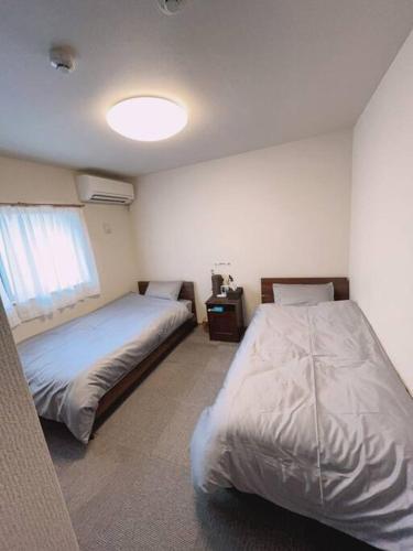a bedroom with two beds and a window at 栖禾 seika in Nagoya