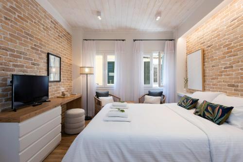 ein Schlafzimmer mit einem weißen Bett und einer Ziegelwand in der Unterkunft La Signora Cofineta by Anita Holiday Homes in Korfu-Stadt