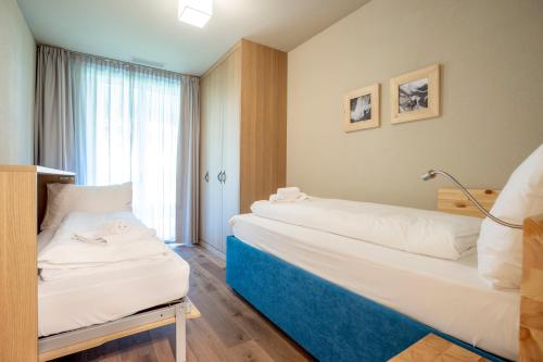 a hotel room with two beds and a window at SWISSPEAK Resorts Meiringen in Meiringen