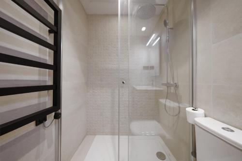 a bathroom with a shower and a toilet and a sink at Numa Madrid Sol in Madrid