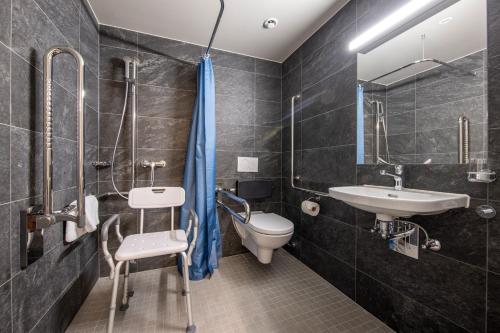 uma casa de banho com um lavatório e um WC em SWISSPEAK Resorts Meiringen em Meiringen