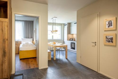 a small apartment with a bedroom and a table at SWISSPEAK Resorts Meiringen in Meiringen