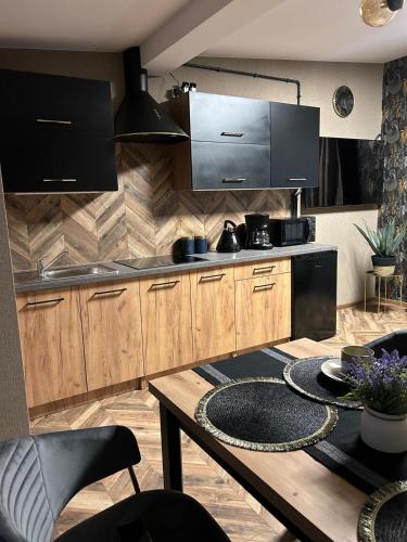 a kitchen with wooden cabinets and a wooden table at Apartament przy plaży Marlina in Niewiesze