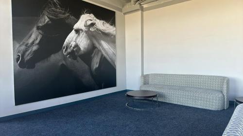a room with a picture of two horses on the wall at Destiny Hotel in Harhorin