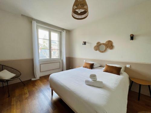 une chambre avec un grand lit blanc avec une fenêtre dans l'établissement L'ORFÈVRE - hypercentre, lumineux, vue cathédrale, à Blois