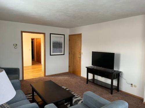 a living room with a couch and a table and a television at Prime Location Amazing Unit Close to Downtown - 2 queen beds in Springfield