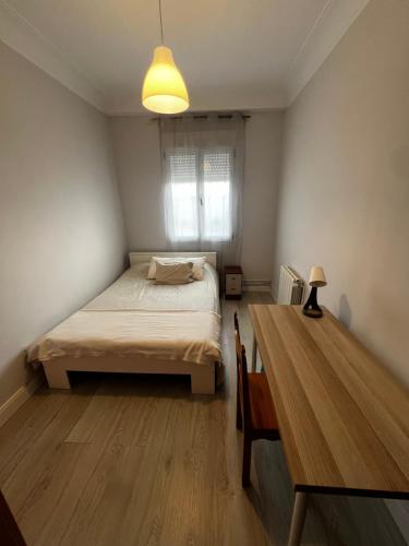 a bedroom with a bed and a table in it at 3 habitaciones reformado y centrico in Santander