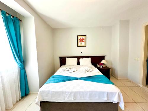 a bedroom with a large bed with blue curtains at Villa Anfora in Datca