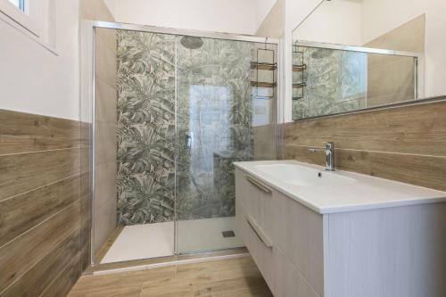 a bathroom with a shower with a sink and a mirror at Appartamento La Pergola in Moniga