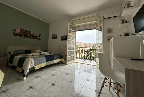 1 dormitorio con cama y vistas a un balcón en La Madonnina, en Noto