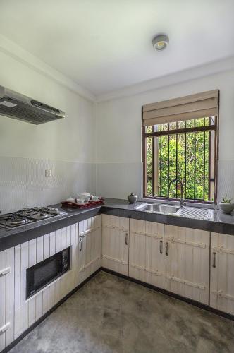 an empty kitchen with a sink and a window at Villa Touch of Dutch in Tangalle