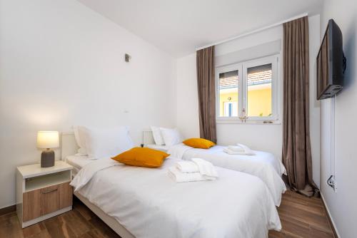 2 witte bedden in een kamer met een raam bij First Choice Apartment Rogoznica in Rogoznica