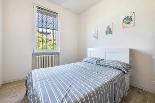 a bedroom with a bed with a blue and white comforter at Appartamento La Pergola in Moniga