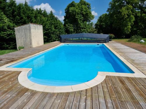 une piscine sur une terrasse en bois avec un banc au-dessus dans l'établissement Tanzanite - 6 couchages, à Archigny