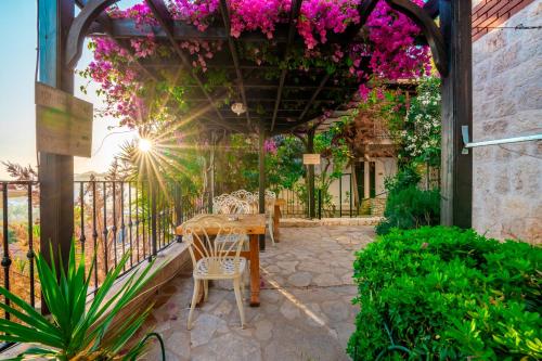 a patio with a table and chairs and flowers at Luna Kaş in Kas
