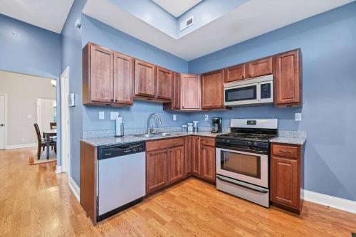 an empty kitchen with wooden cabinets and appliances at St Louis Tower Grove Two-Story Townhome Perfect for Groups Side A in Tower Grove