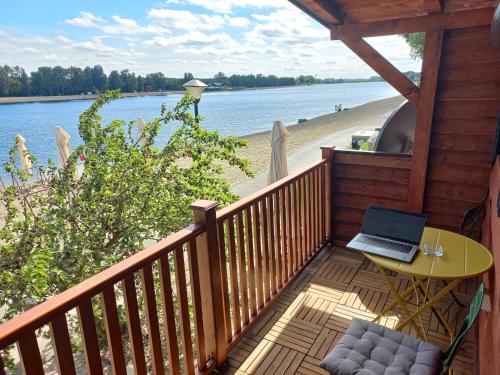 a balcony with a table and a laptop on the beach at Island Ada in Čukarica
