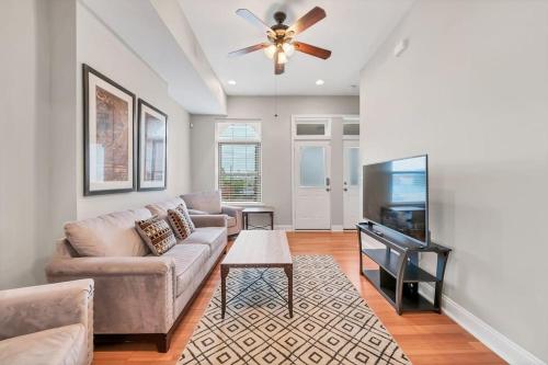 a living room with a couch and a flat screen tv at St Louis Tower Grove Two-Story Townhome Perfect for Groups Side B in Tower Grove