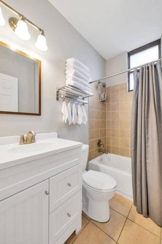 a white bathroom with a sink and a toilet at St Louis Tower Grove Two-Story Townhome Perfect for Groups Side B in Tower Grove
