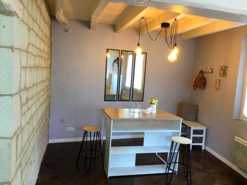 une cuisine avec un comptoir et des tabourets dans une pièce dans l'établissement Les Perdrielles, à Fontevraud-l'Abbaye