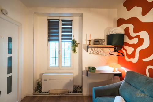 un salon avec un canapé bleu et une fenêtre dans l'établissement Découvrez Marseille depuis le Panier - Solo/Duo, à Marseille