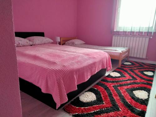 a bedroom with two beds and a rug at Apartman Kumalic in Sanski most