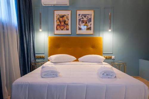 a bedroom with a large bed with two towels on it at L Suites The Writer's House in Gythio