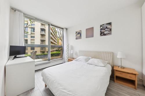une chambre blanche avec un lit et une fenêtre dans l'établissement Appartement cosy proche porte maillot, à Neuilly-sur-Seine