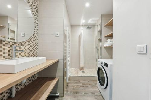 une salle de bain avec un lavabo et une machine à laver dans l'établissement Appartement cosy proche porte maillot, à Neuilly-sur-Seine