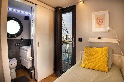 a bedroom with a bed with a yellow pillow at The Homeboat Company Sant'Elmo-Cagliari in Cagliari