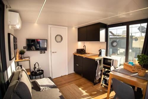a living room with a couch and a kitchen at The Homeboat Company Sant'Elmo-Cagliari in Cagliari