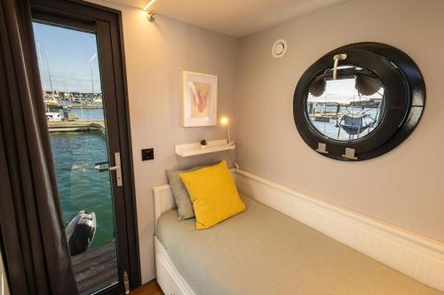 a window seat in a boat with a yellow pillow at The Homeboat Company Sant'Elmo-Cagliari in Cagliari