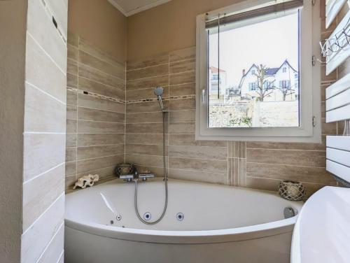 une baignoire dans une salle de bain avec une fenêtre dans l'établissement Duplex T2 Bords de Seine, à Meulan-en-Yvelines
